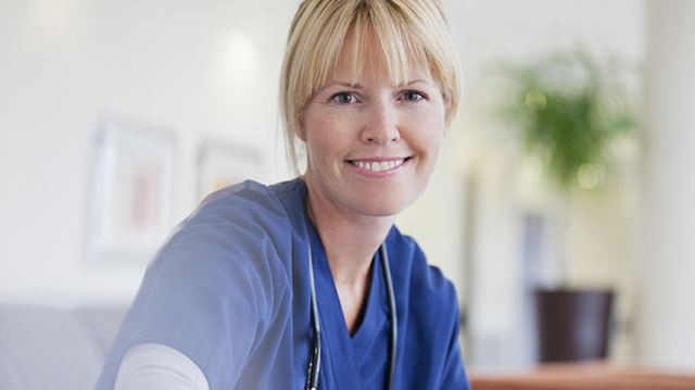 The initiatives helping to boost mental wellbeing among NHS staff; nurse smiling